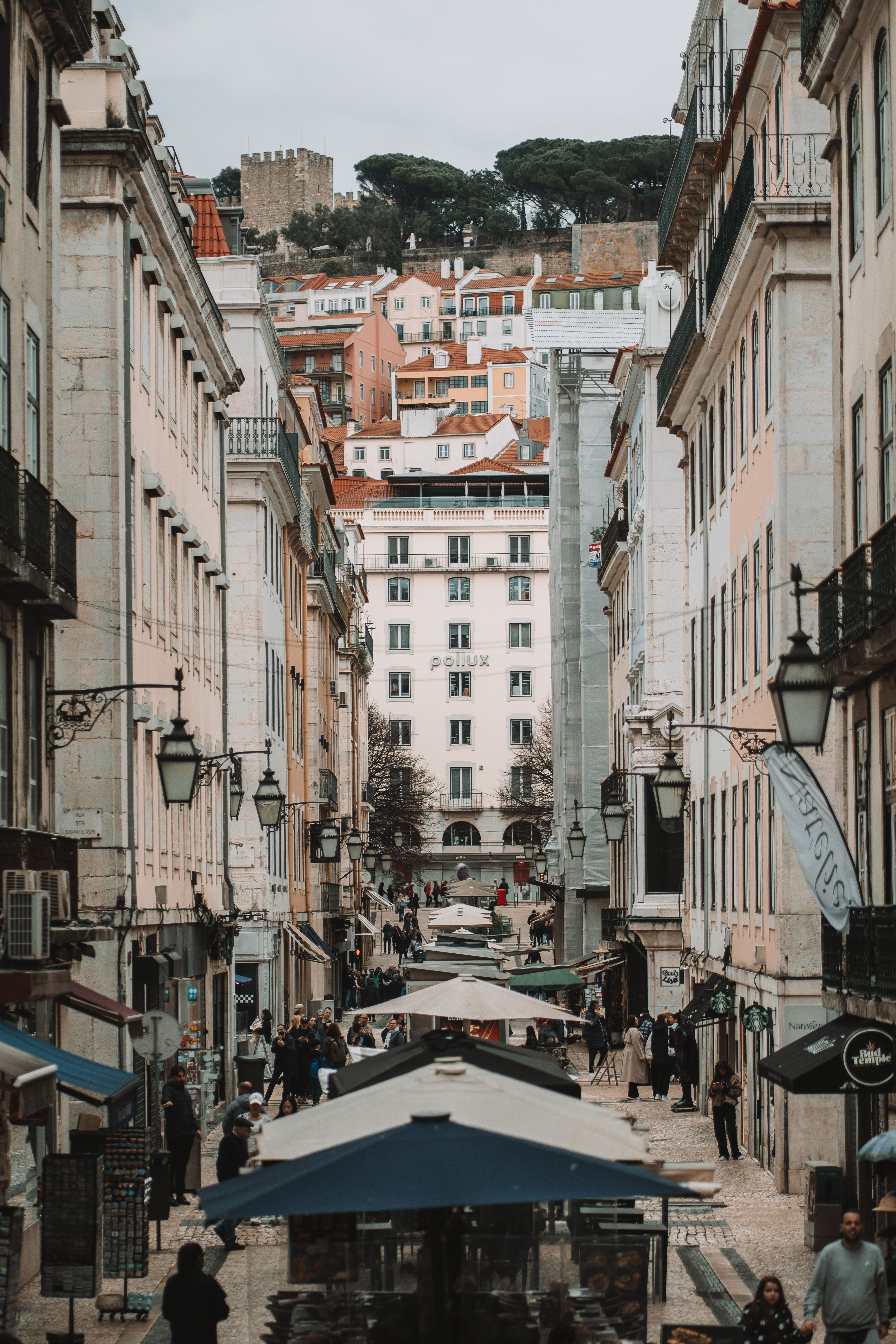 Explore Lisbon's lively streets with historic architecture and bustling atmosphere.