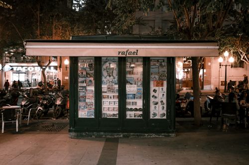 Free Nighttime scene of a street vendor in Alicante, Spain with warm urban ambiance. Stock Photo