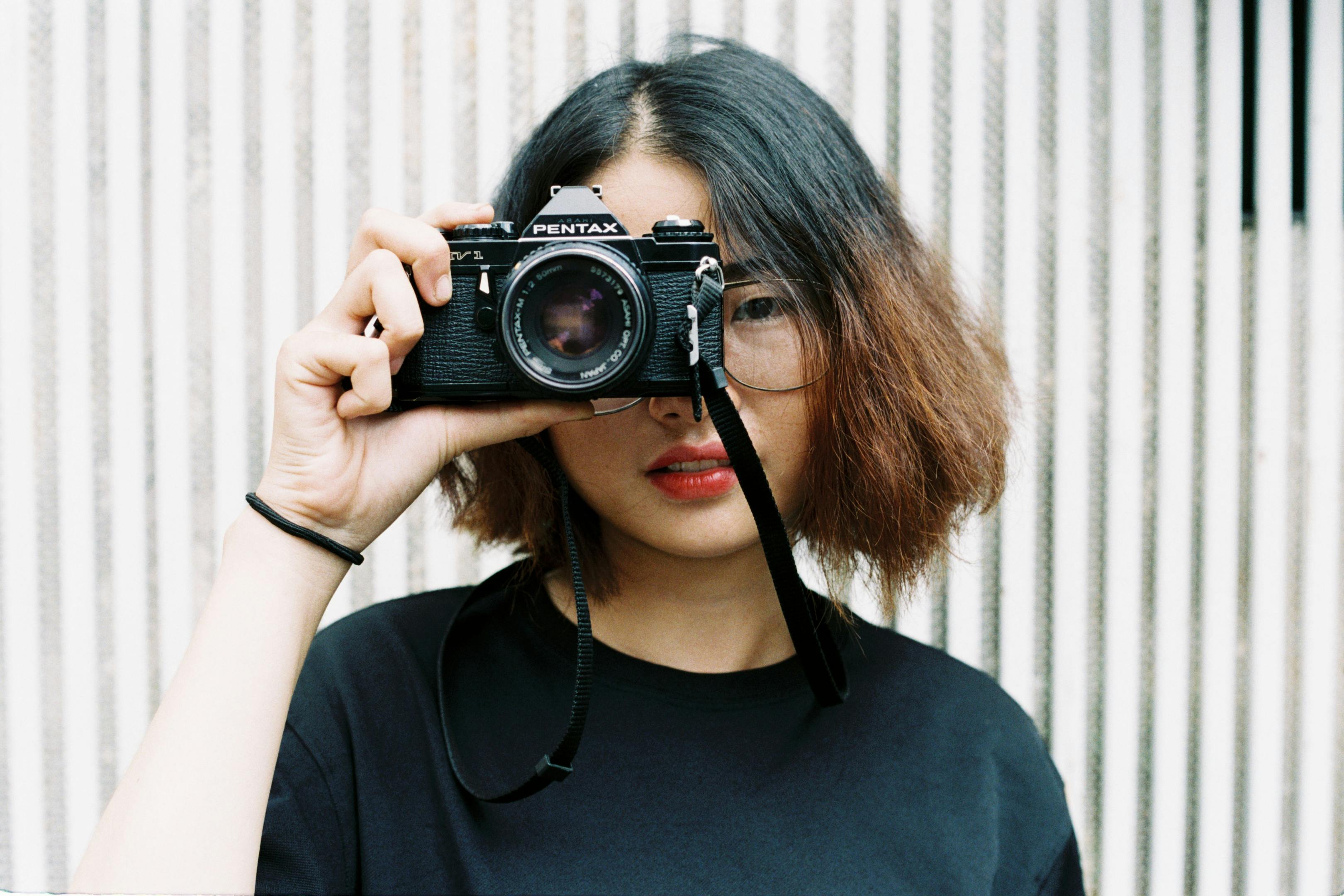 Portrait of a young woman holding a vintage camera in Ho Chi Minh City.