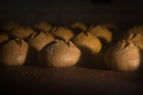 Free Warmly lit image of artisanal breads baking in an oven, showcasing rustic textures and craft. Stock Photo