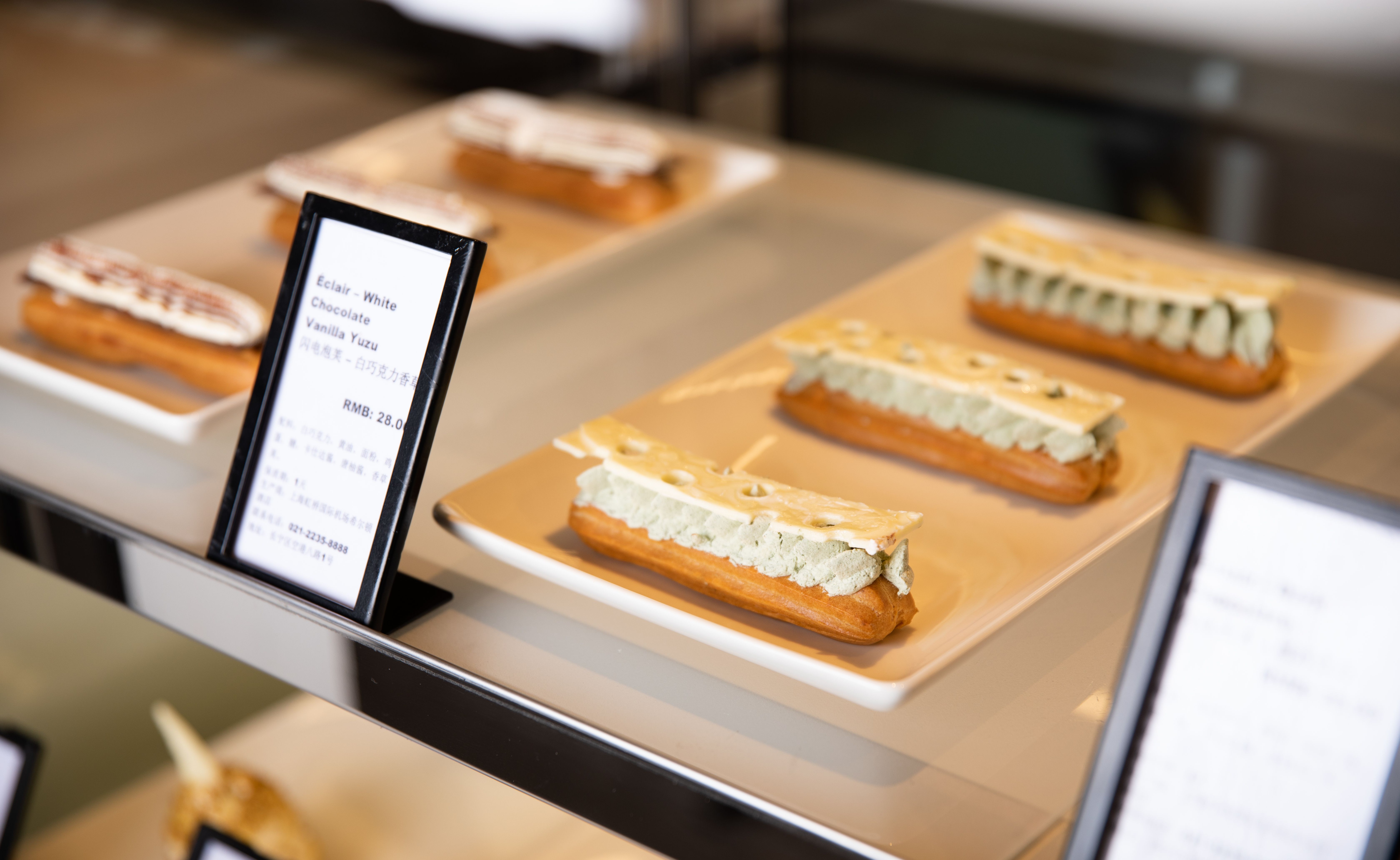 Delicious eclairs with white chocolate and yuzu cream displayed elegantly on plates.