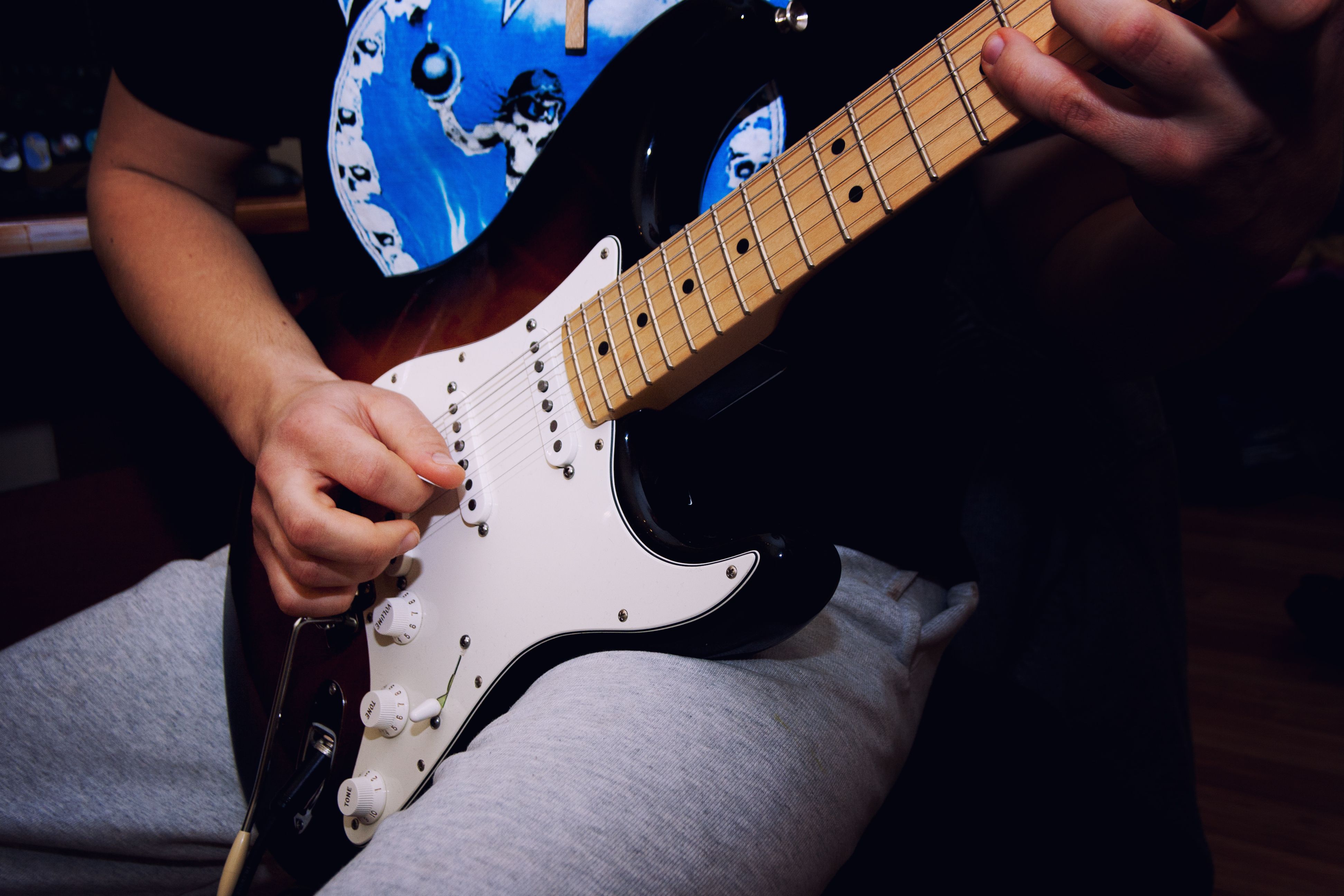 A musician strumming an electric guitar with focused hands, showcasing rock music vibes.