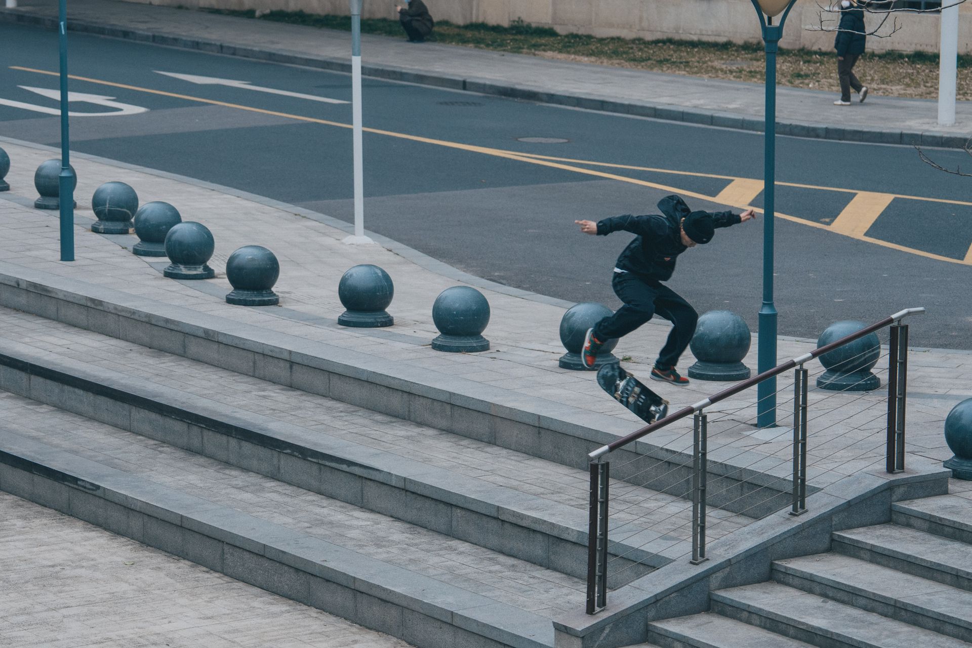Dynamic shot of skateboarder executing a flip trick on city steps. Urban lifestyle captured.