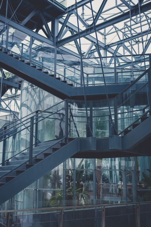Free Industrial-style staircase in a glass-walled building showcasing urban architecture elements. Stock Photo
