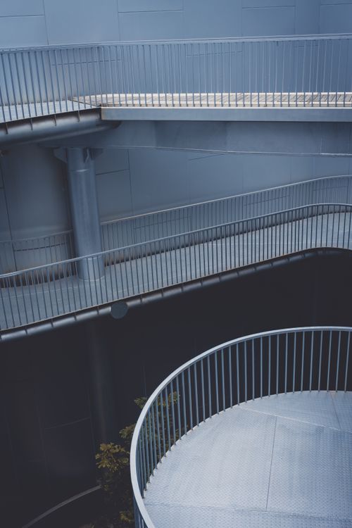 Free Sleek spiral staircase in a modern building with blue tones and industrial style. Stock Photo