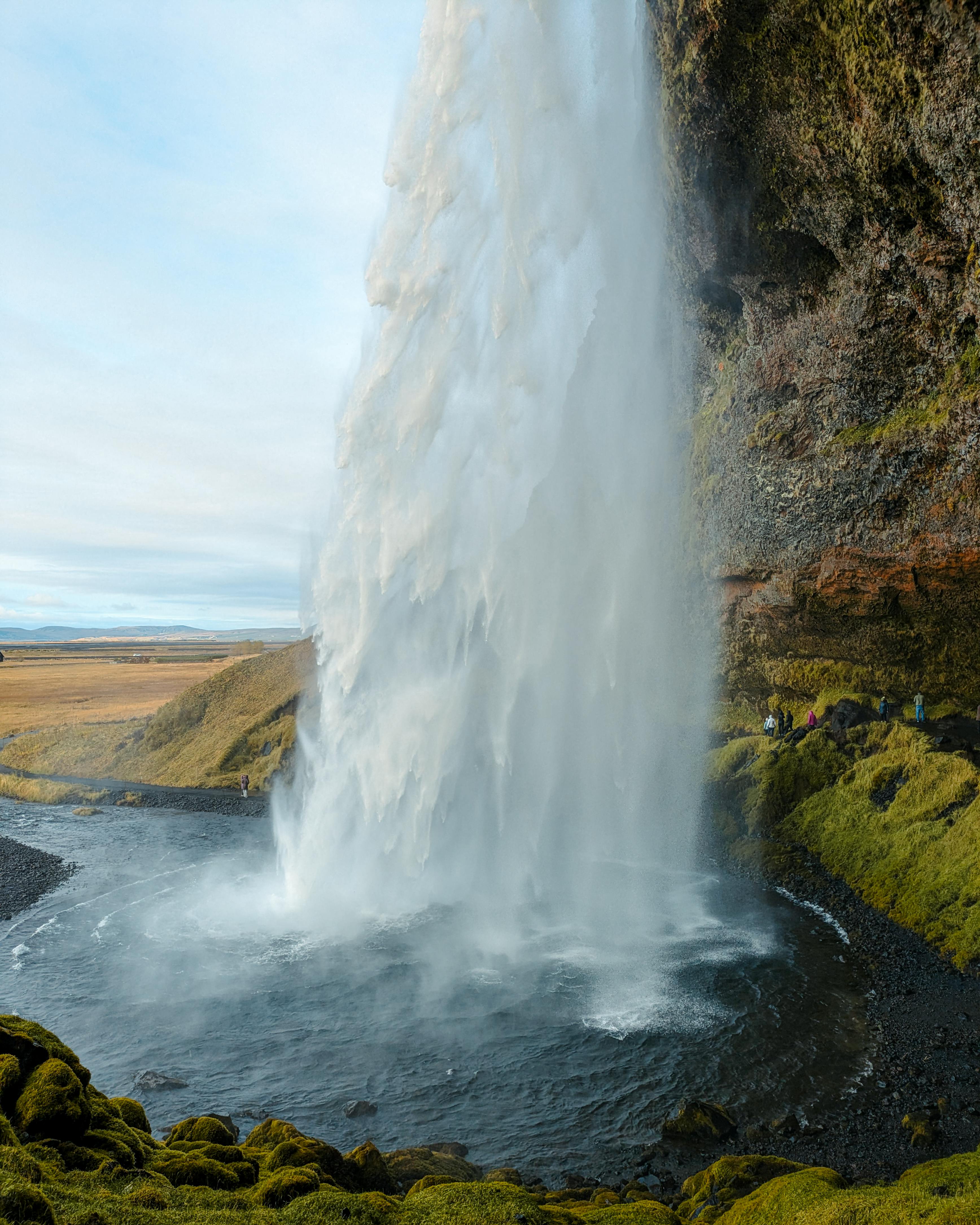 Breathtaking view of a cascading waterfall in Iceland, surrounded by rugged scenery.