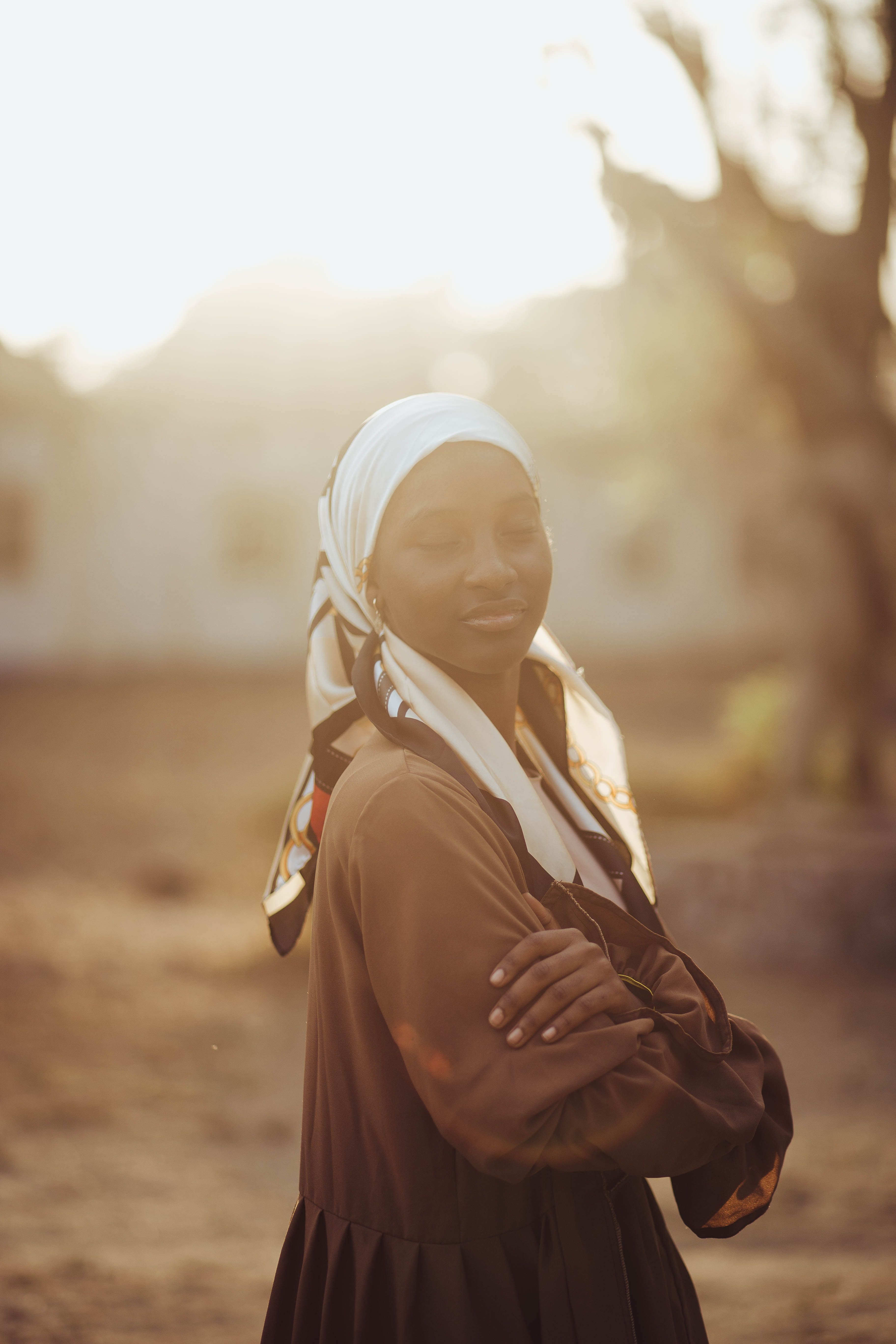 Woman in Hijab Standing Outdoors at Sunset · Free Stock Photo