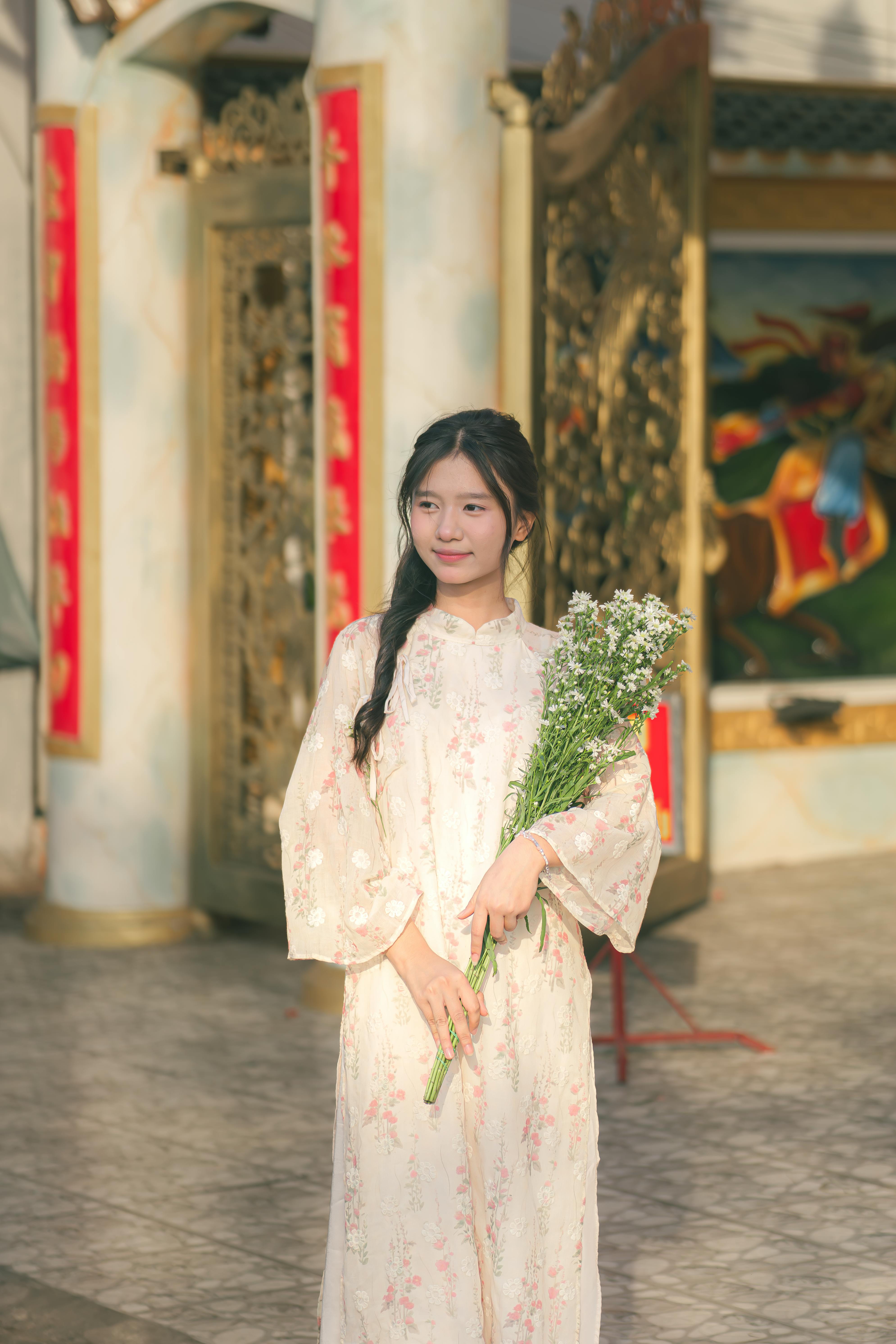 young woman in traditional dress holding flowers