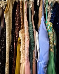 A vibrant collection of vintage dresses hanging on racks, showcasing diverse styles and fabrics.