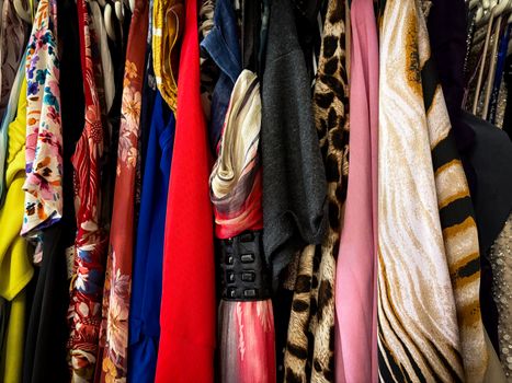 A vibrant collection of vintage clothes on hangers showcasing various patterns and fabrics.
