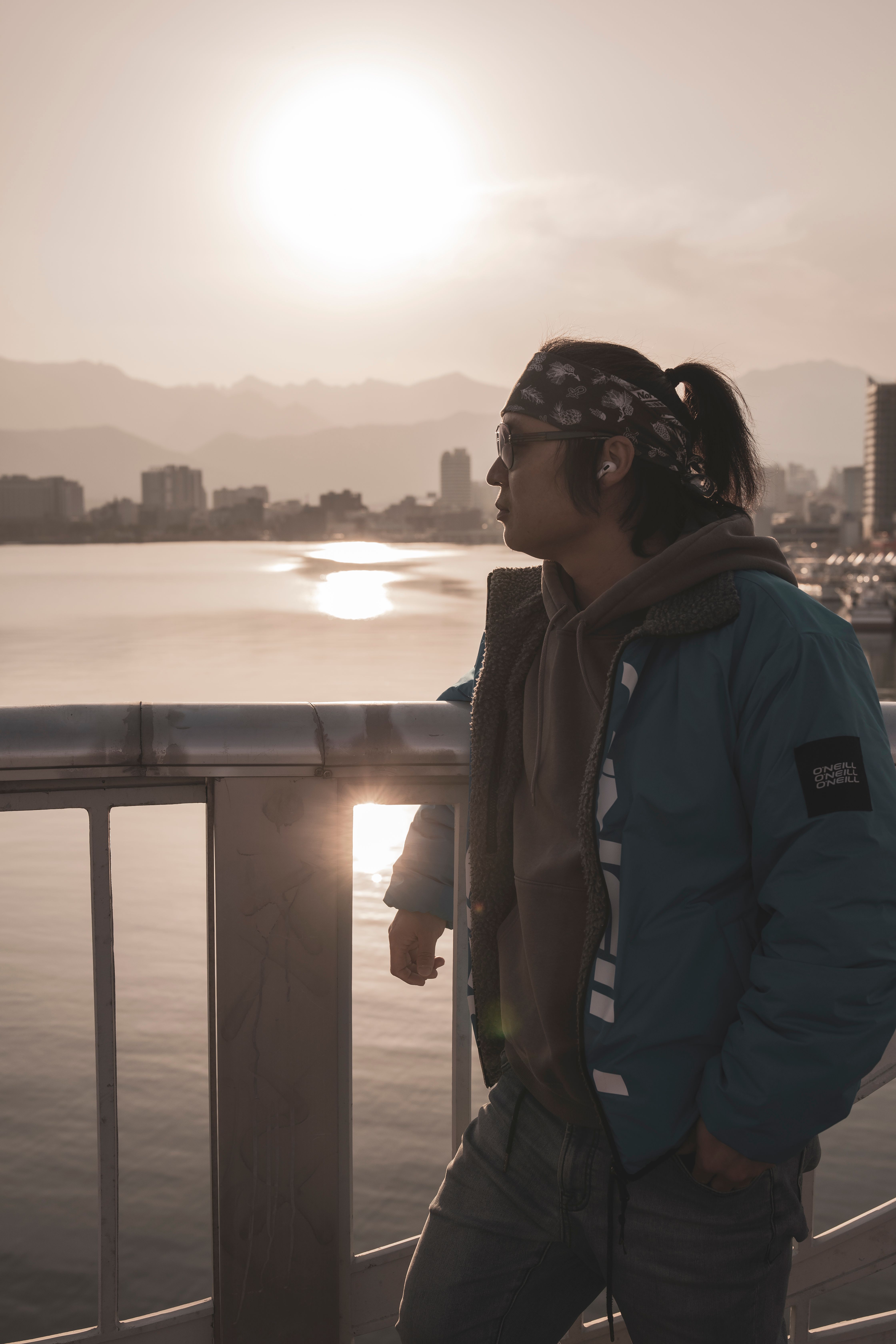 Contemplative Urban Sunset on Waterfront · Free Stock Photo