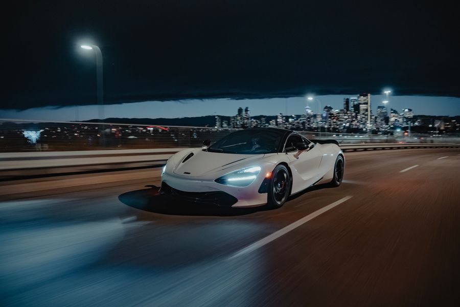 White sports car cruising on a highway at night