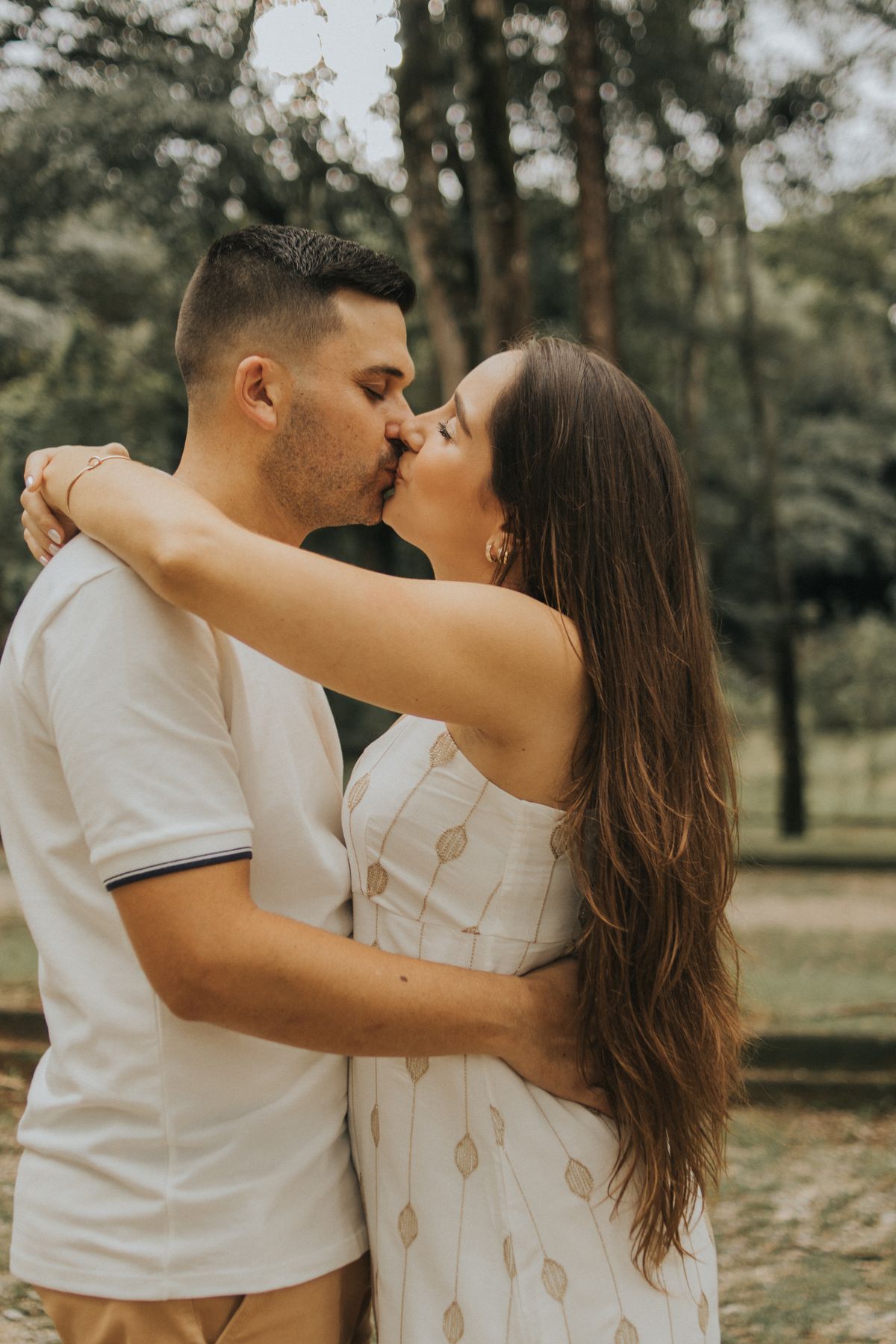 A couple sharing a tender kiss in a park, embracing warmly