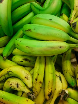 A vibrant collection of fresh yellow bananas displayed at an outdoor market stand.