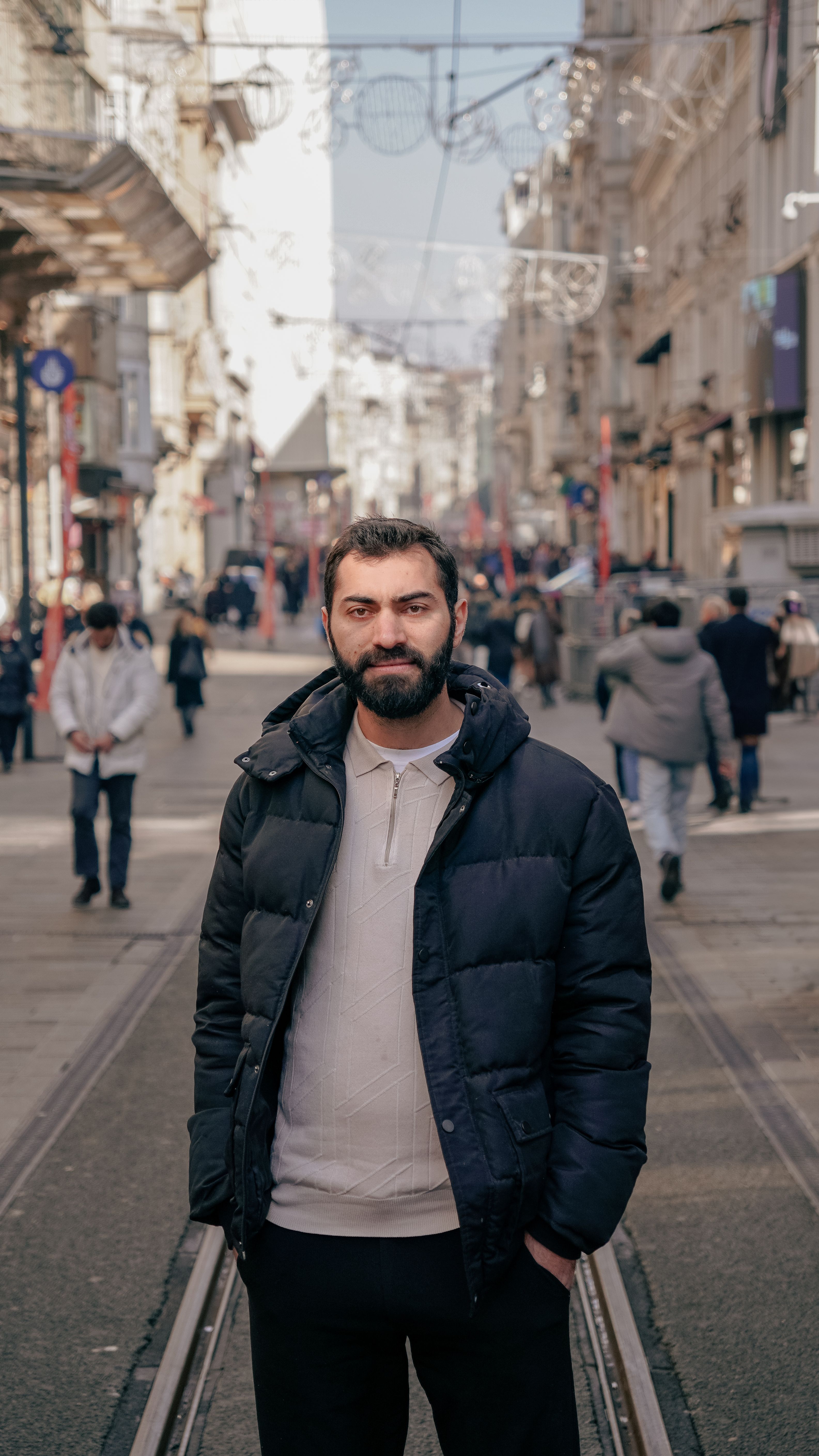 Casual portrait of a man amidst the lively atmosphere of a street in Istanbul, showcasing urban life.