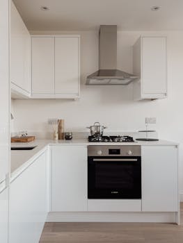 Minimalist white kitchen with sleek appliances in Warsaw