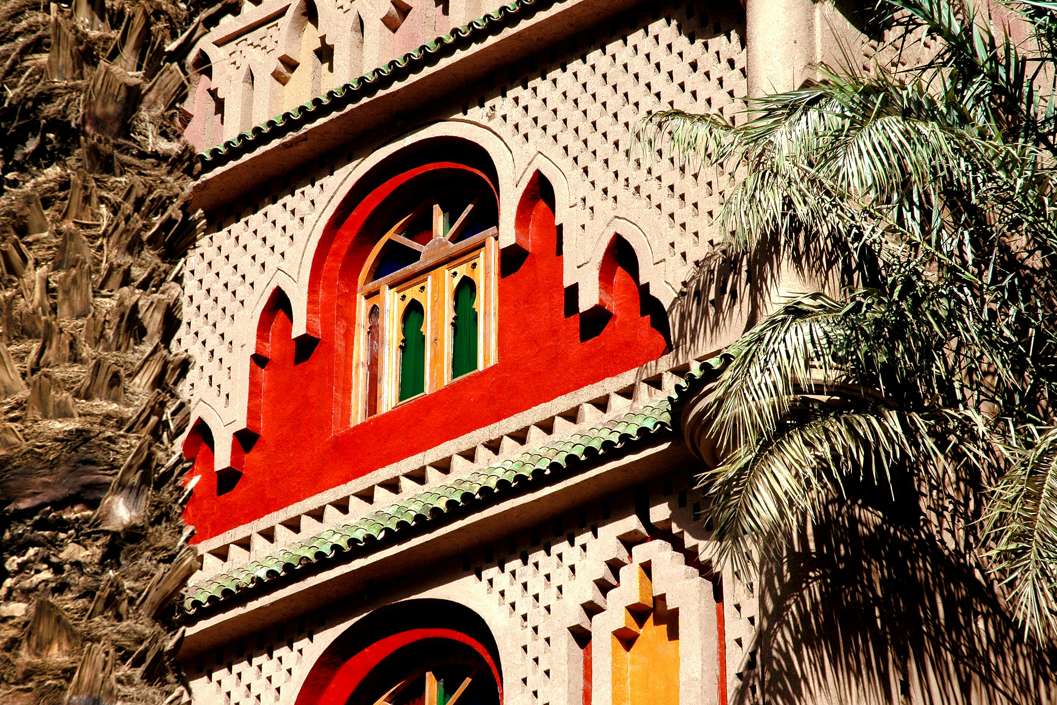 Ornate Moroccan building facade with traditional architecture and palm trees in Zagora.