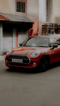 A vibrant red Mini Cooper parked on a city street, showcasing modern urban life.