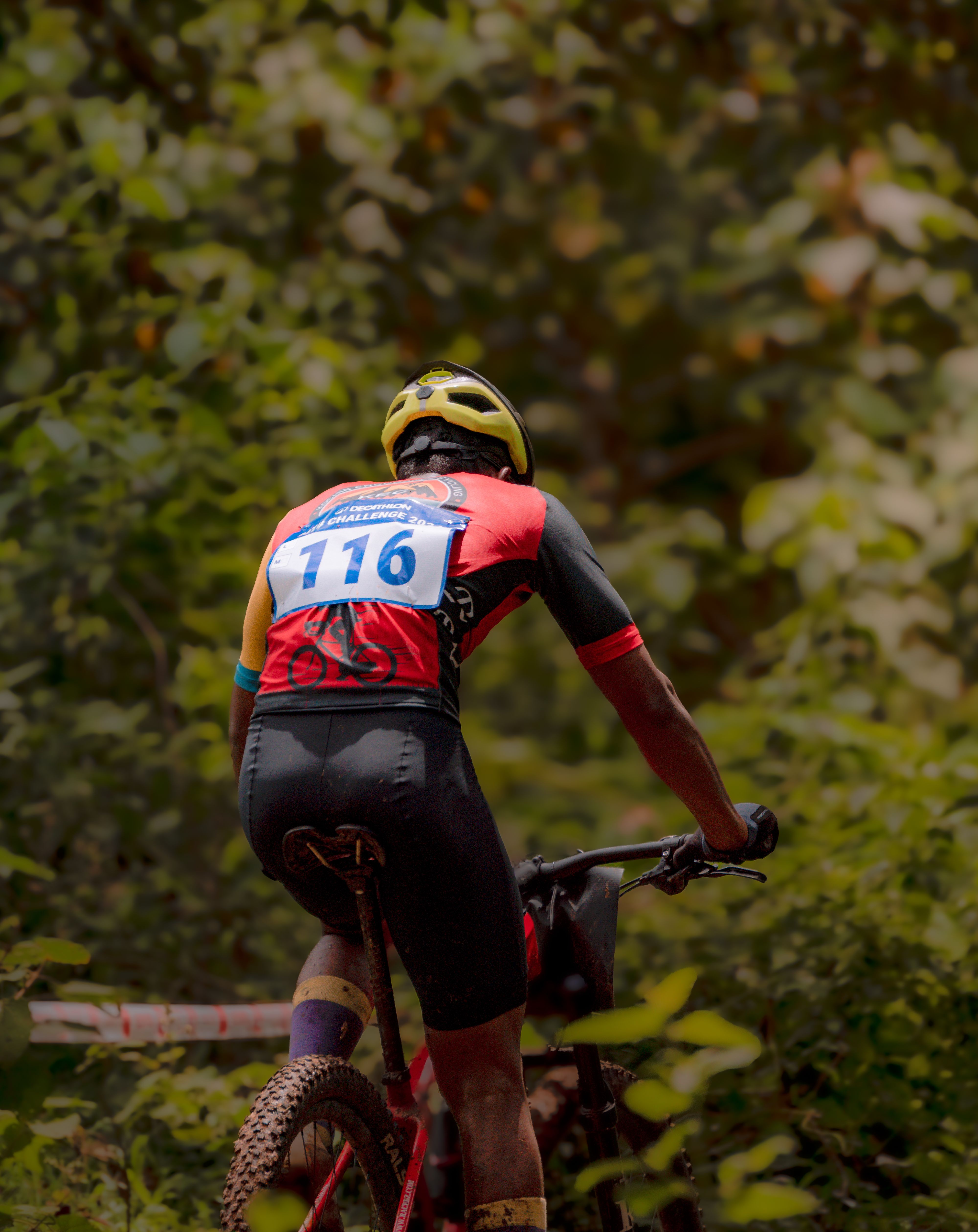 Mountain biker racing through a forested trail in full protective gear