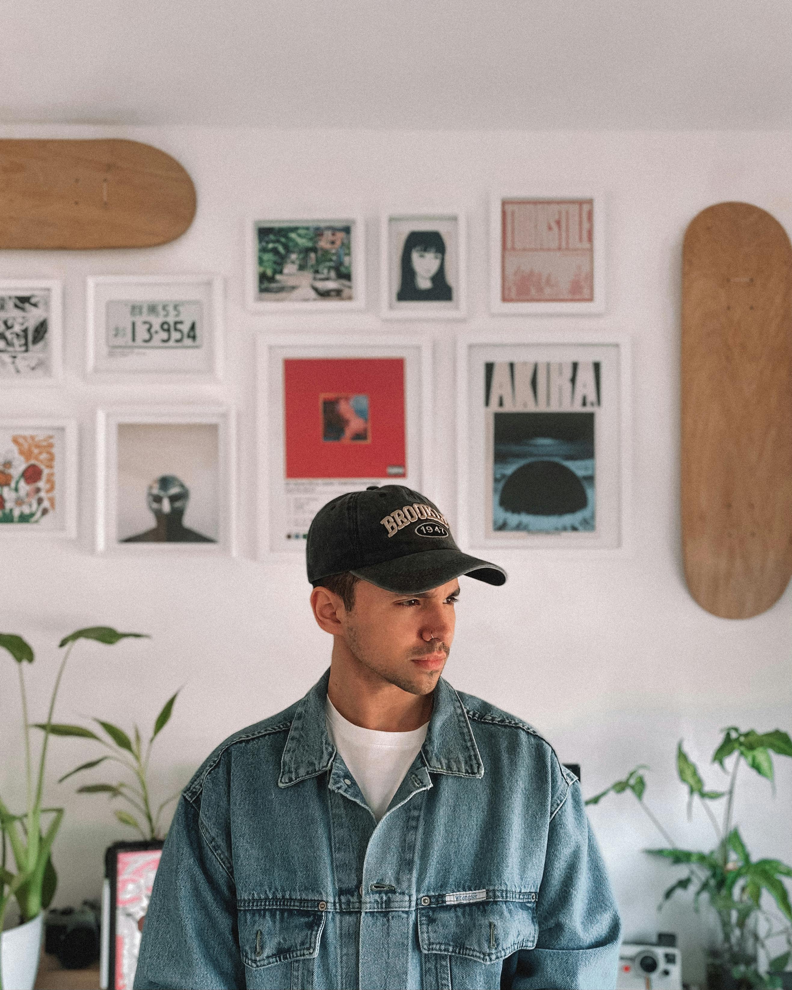 Young man in denim jacket in a decorated room with art and plants, Buenos Aires.