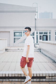 在城市环境中，现代人穿着墨镜和休闲装，时尚地摆着姿势