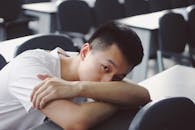 亚洲人在教室里放松，趴在桌上休息，气氛平静祥和