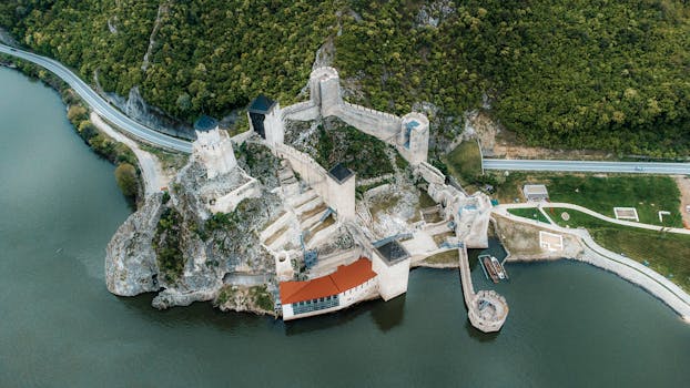 Stunning aerial photograph of Golubac Fortress with the Danube River in Serbia surrounded by lush greenery.