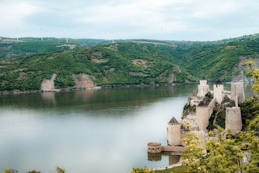 Aerial view of Golubac Fortress along the Danube River in Serbia, surrounded by lush greenery.