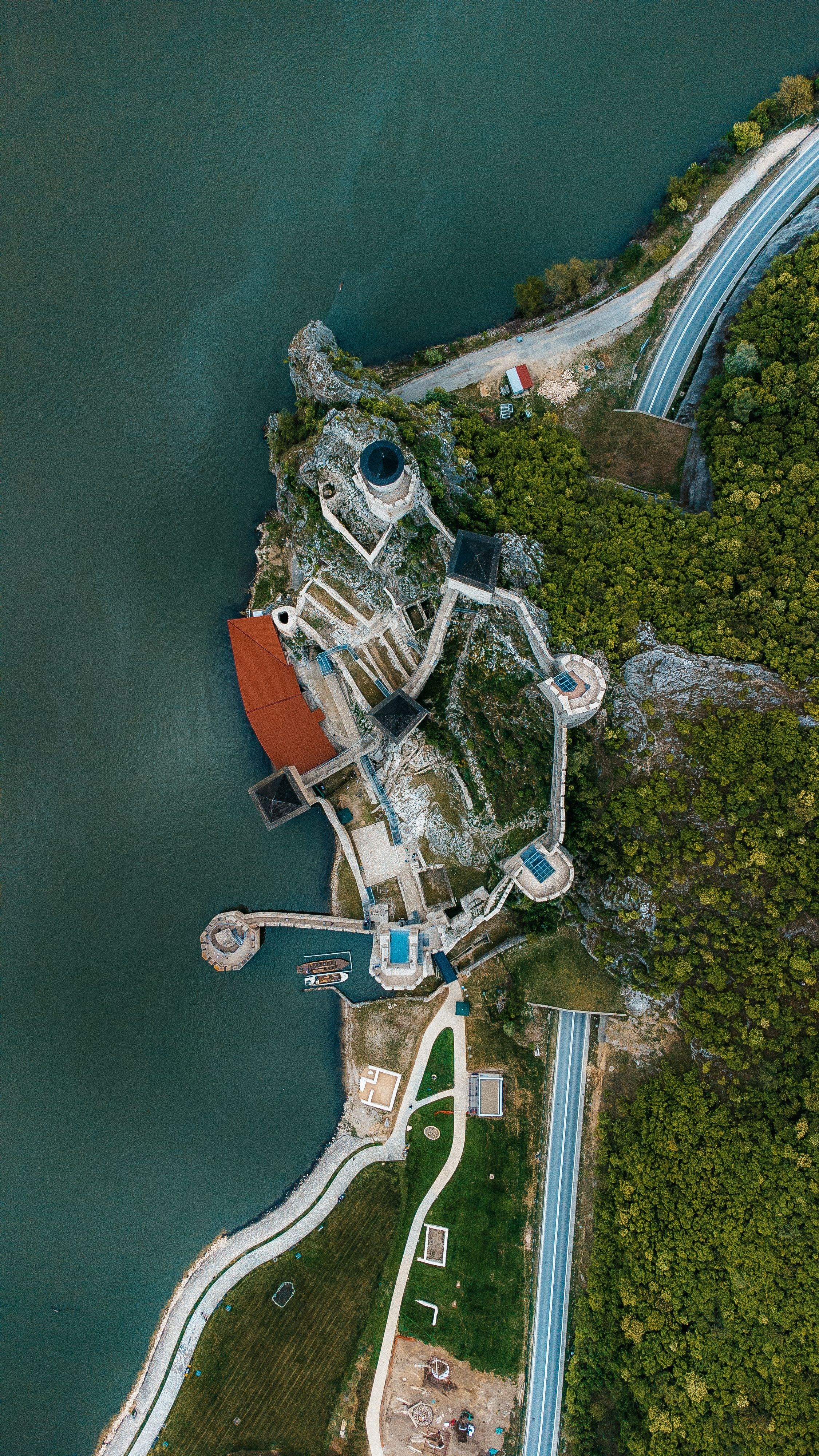 Stunning aerial view of Golubac Fortress and winding roads along the Danube River in Serbia.
