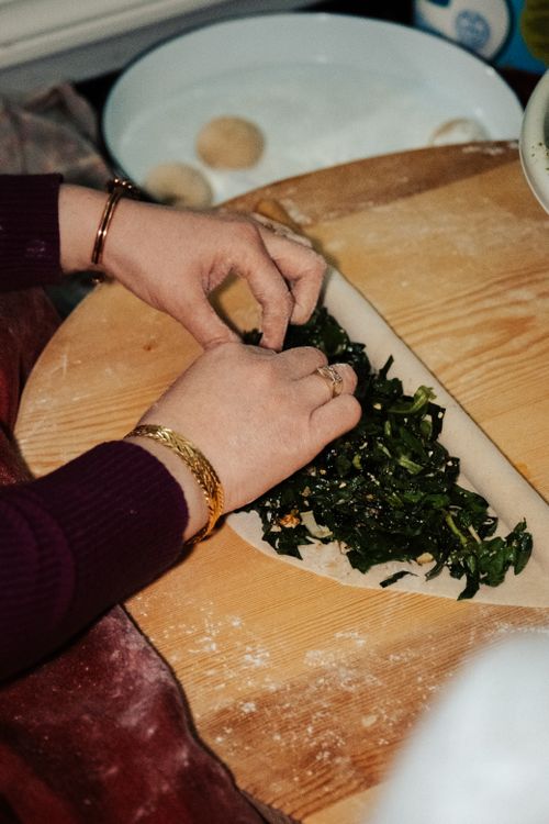 Free Hands rolling spinach borek in a kitchen setting, capturing Turkish culinary tradition. Stock Photo