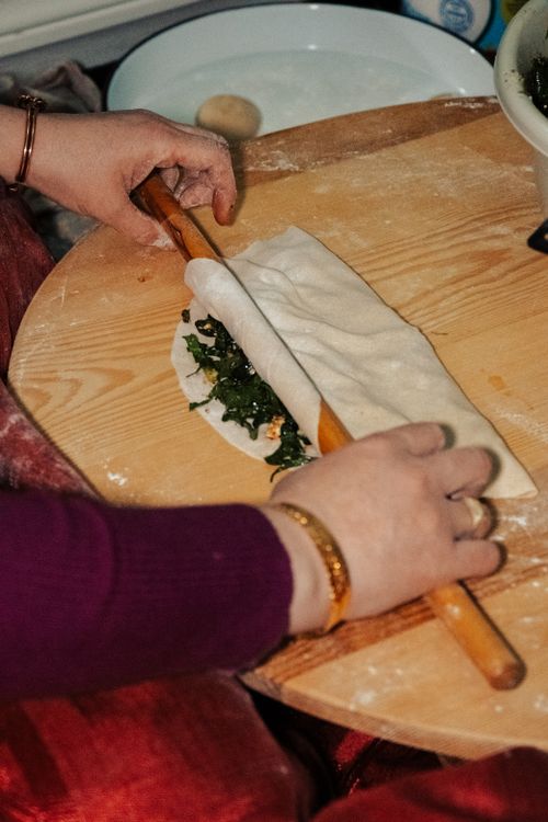 Free Hands rolling dough with greens in a traditional Turkish kitchen. Stock Photo