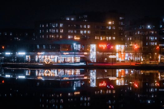 Stunning nighttime cityscape of Jönköping, Sweden, reflecting on water.