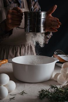 A cozy kitchen moment capturing the process of sifting flour for baking desserts.