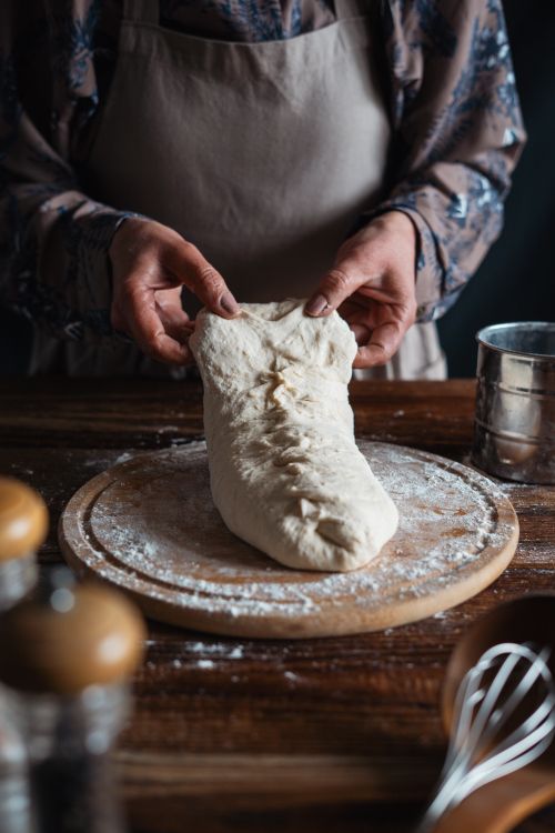 Free Hands kneading dough in a rustic kitchen, ideal for culinary themes. Stock Photo
