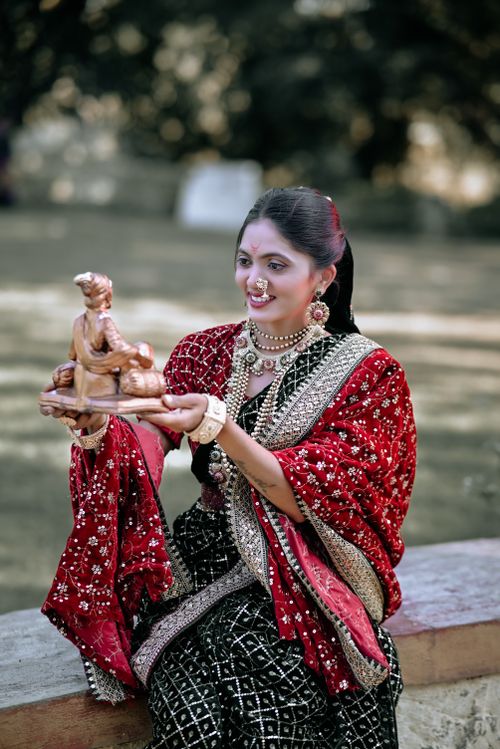 Free Smiling Indian woman in traditional dress holds a Krishna statue outdoors. Stock Photo