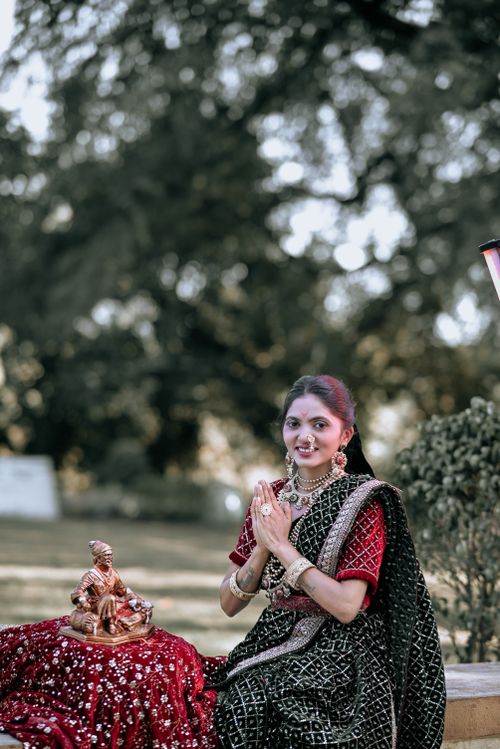 Free A woman in traditional Indian attire sitting outdoors with a decorative statue, embracing cultural motifs. Stock Photo