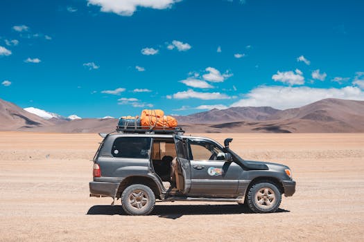 4x4 vehicle in Bolivia's Uyuni Salt Flat surrounded by stunning desert scenery.