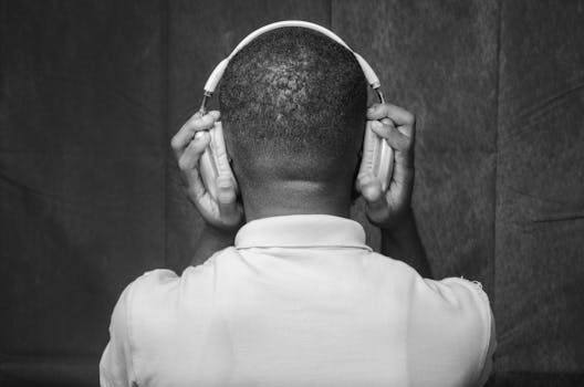 Artistic black and white portrait of a man wearing headphones from behind.
