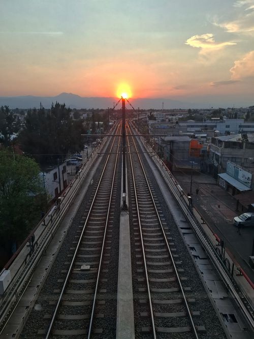 Free Beautiful sunset view over railway tracks in a sprawling urban area, capturing vibrant colors and serene ambiance. Stock Photo