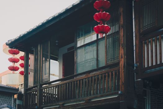 An authentic wooden balcony adorned with red lanterns highlighting cultural heritage.