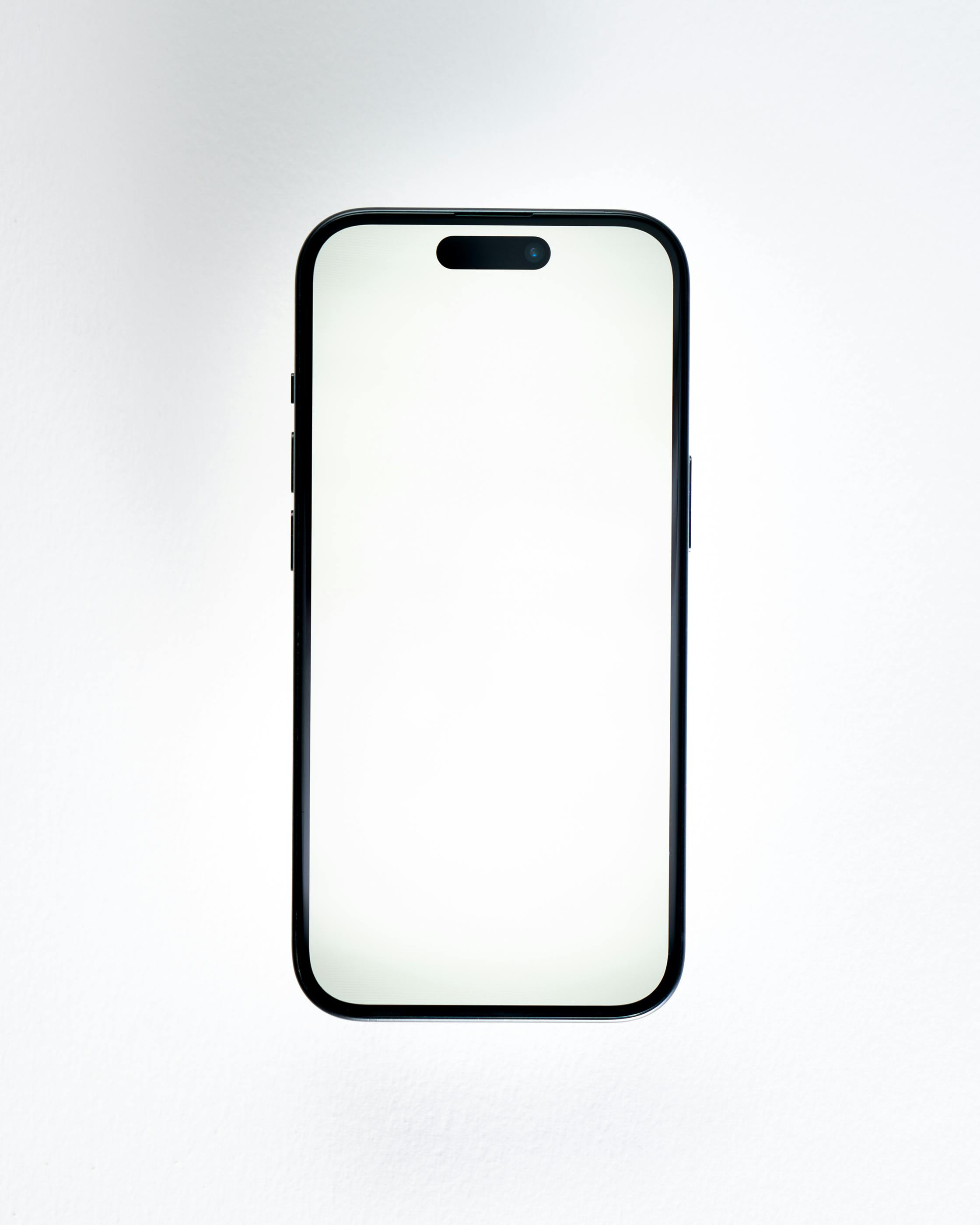 Gratis Mockup telepon pintar menghadap depan berkualitas tinggi dengan layar kosong pada latar belakang putih untuk presentasi desain. Foto Stok