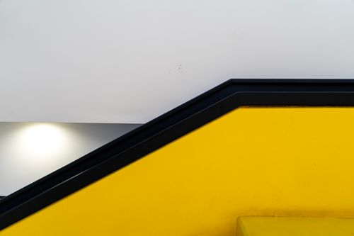 Free Modern architecture with geometric lines and a striking yellow wall, perfect for creative design concepts. Stock Photo