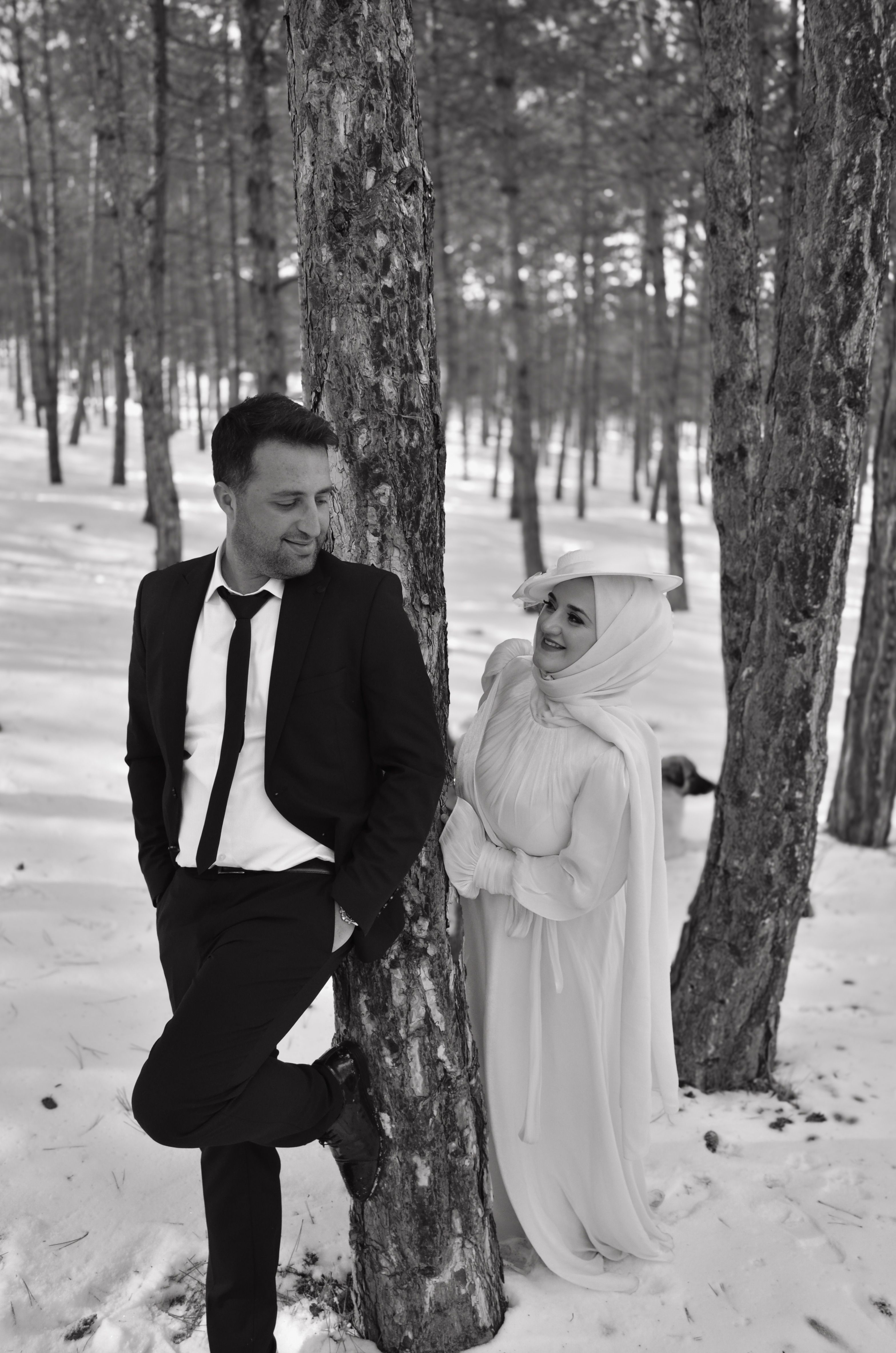 Bride and groom share a romantic moment in a snowy forest setting, perfect for winter weddings.