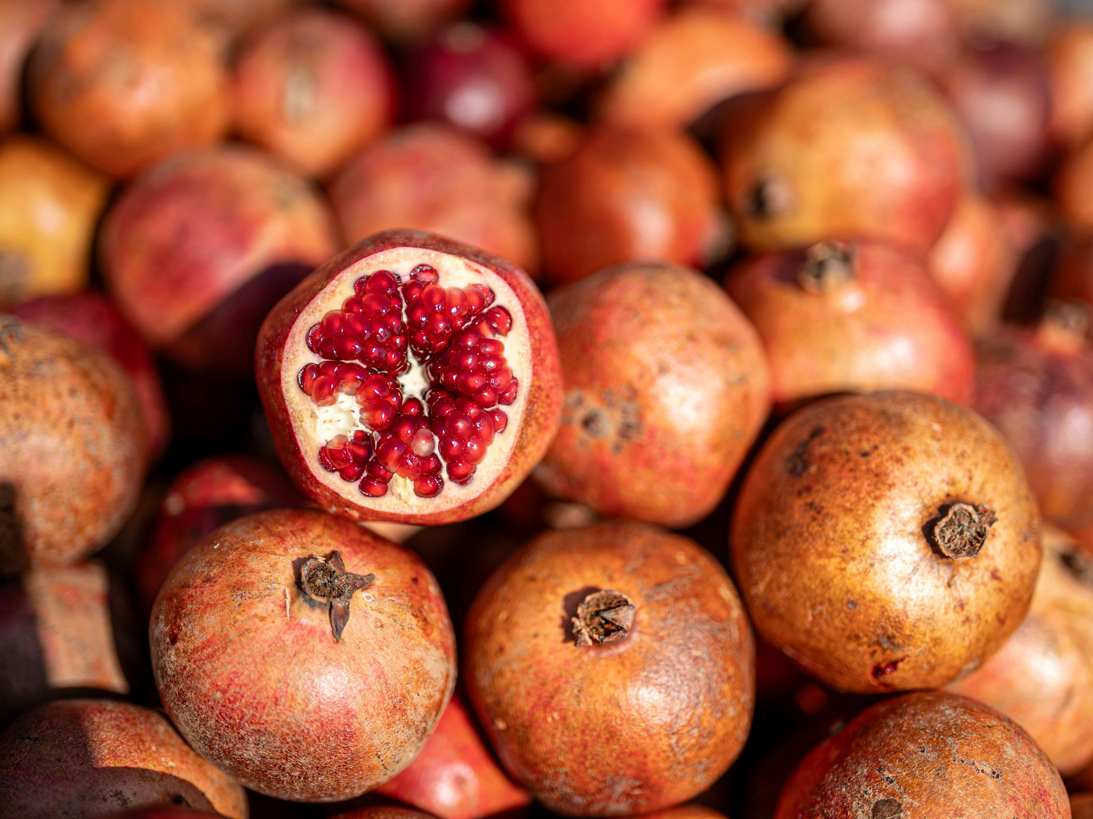Close-up of ripe pomegranates with seeds exposed, showcasing fresh produce in Kahramanmaraş.