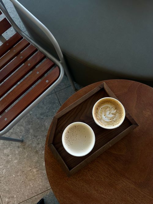 Free Overhead view of cappuccinos on a wooden table in a cozy cafe setting. Stock Photo