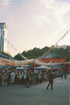 A lively street festival with crowds and decorations under a twilight sky in İstanbul, Türkiye.