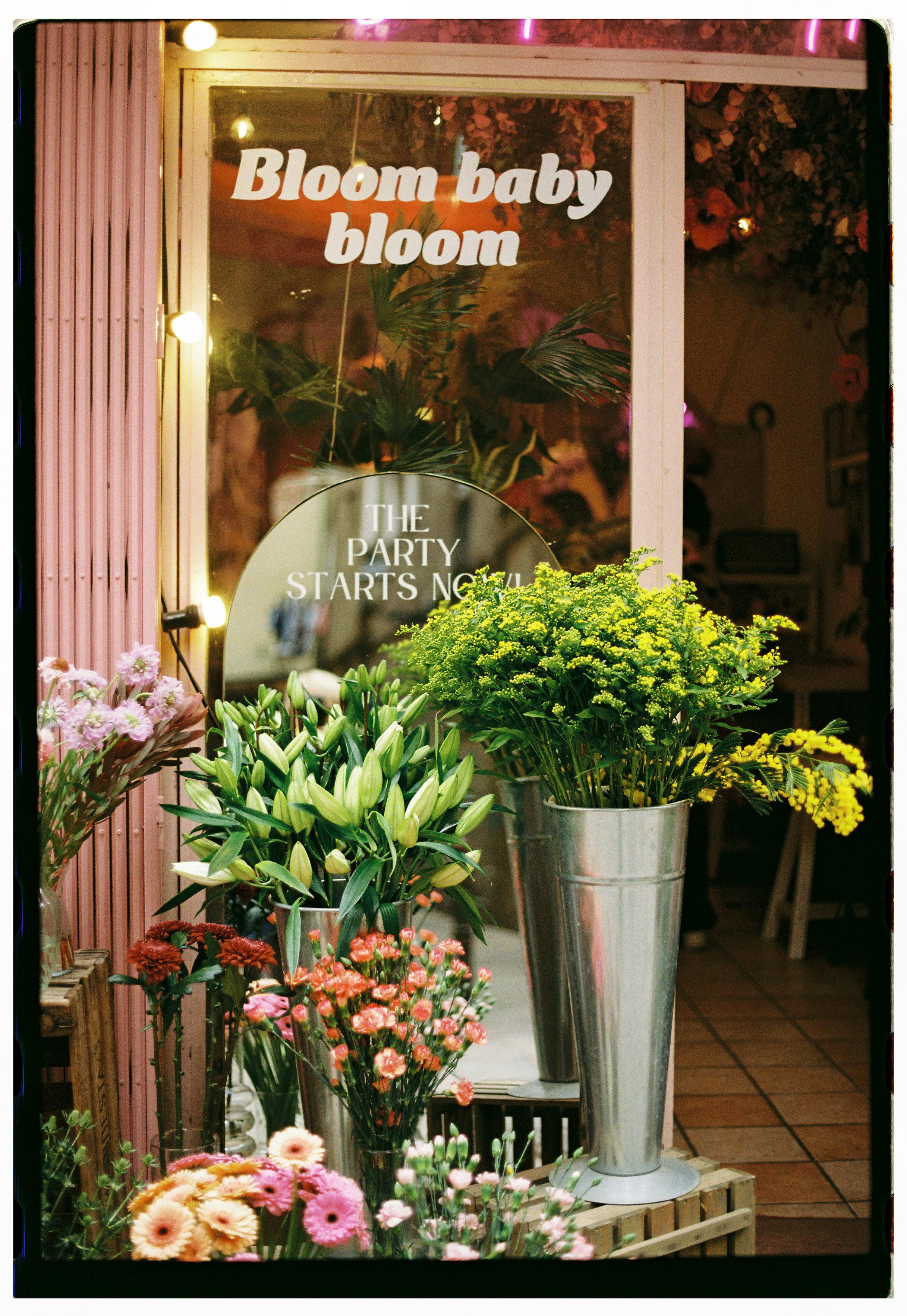Colorful floral arrangements outside a delightful flower shop with inviting signage.