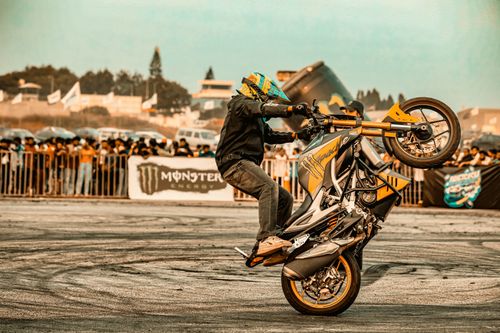Free A thrilling motorcycle stunt performed outdoors in Bengaluru, India, showcasing skill and crowd engagement. Stock Photo
