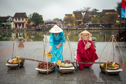 Women in traditional attire selling fruit in Hội An, Vietnam, showcasing vibrant cultural heritage.
