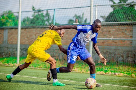 Two soccer players in action, competing for the ball during a match outdoors.
